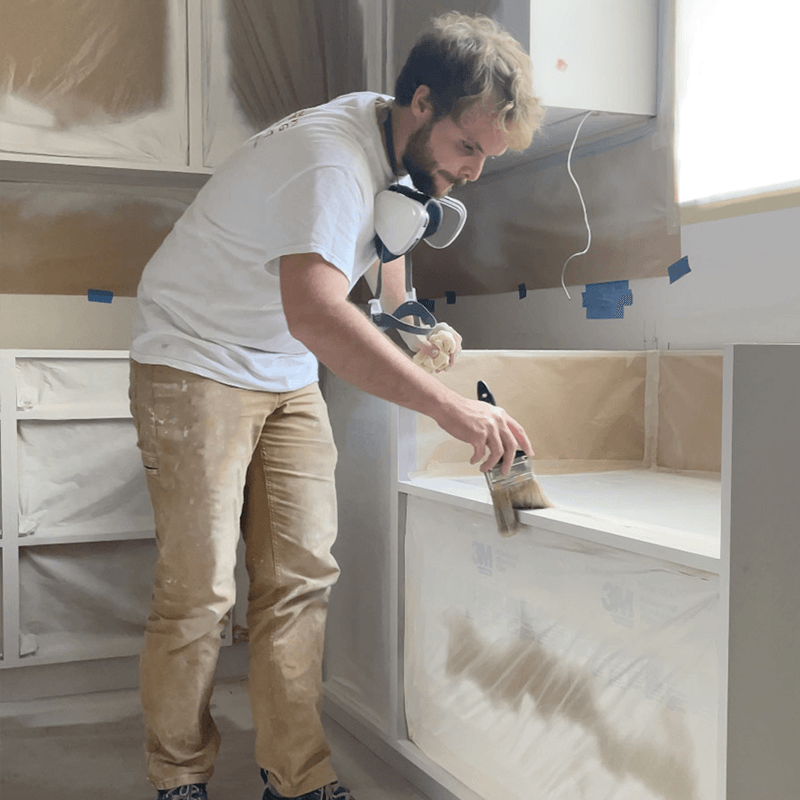 A Paper Moon painter carefully finishing cabinetry